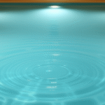 Peaceful therapeutic pool with soft blue water, gentle ripples, warm lighting, serene wellness environment, no text no words no letters