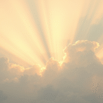 Peaceful healing light rays emanating through soft clouds with warm golden tones representing therapeutic wellness and pain relief no text no words no letters