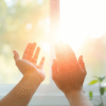 Gentle hands reaching toward soft sunlight streaming through window, peaceful rehabilitation setting with calming blues and greens, hope and healing concept, no text no words no letters