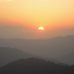 Peaceful sunrise over misty mountains symbolizing hope and new beginnings with soft golden light no text no words no letters