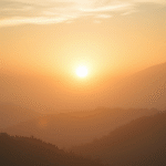 Peaceful sunrise through misty mountains with soft golden light creating serene atmosphere of hope and clarity no text no words no letters