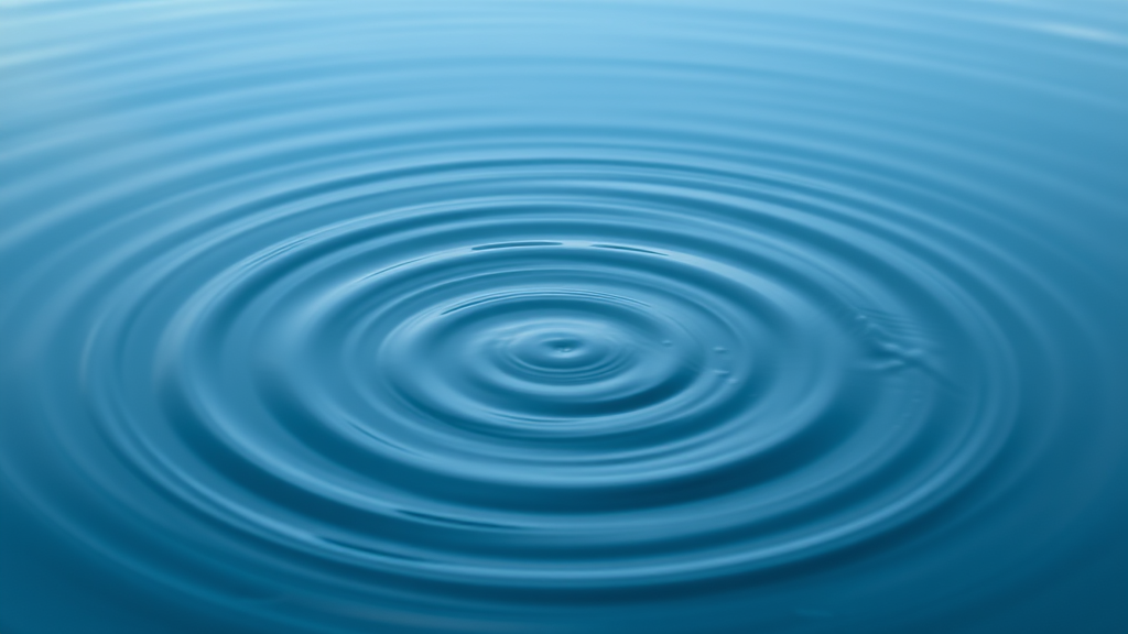 Abstract flowing water creating ripples in tranquil pond representing clarity emerging from stillness with soft blue tones no text no words no letters
