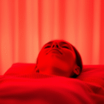 Peaceful person relaxing in warm red light therapy session with soft glowing ambiance and calming atmosphere no text no words no letters