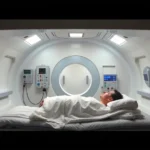 Hyperbaric chamber interior with patient lying down, modern medical facility, clinical setting, bright lighting, sterile environment, oxygen equipment visible